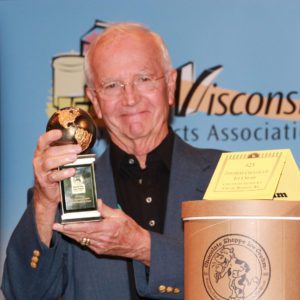 Chuck Sr. Deadman holding an award from the World Dairy Expo.