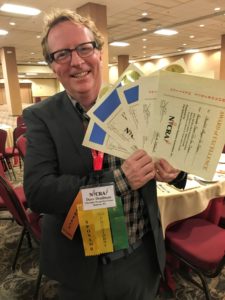 Dave Deadman holding awards from the North American Ice Cream Association.
